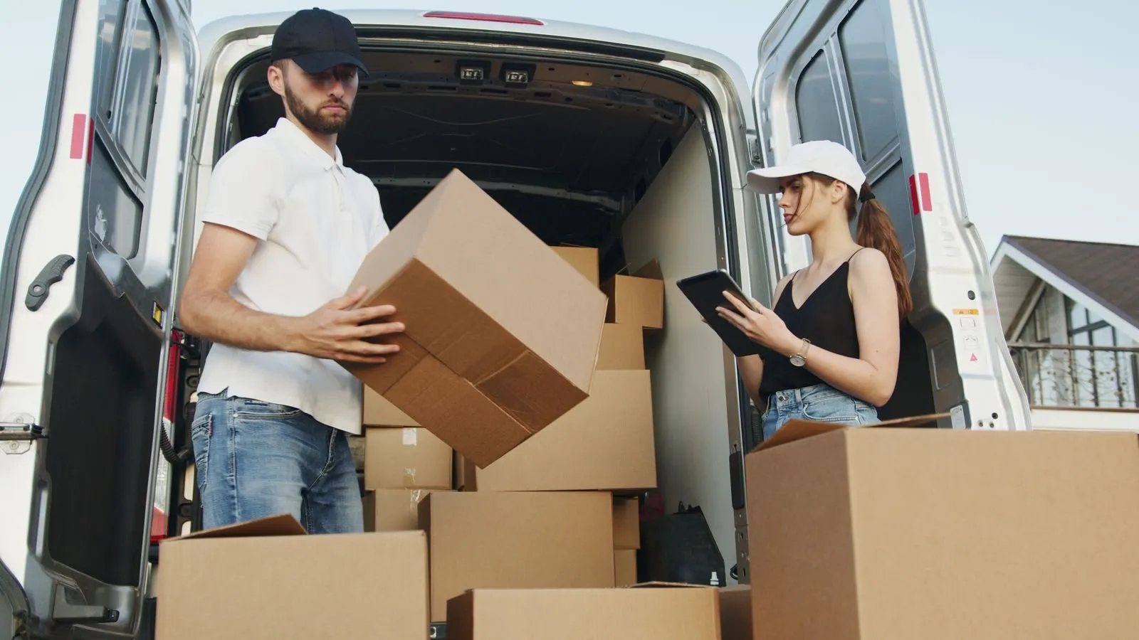 Movers loading cartons into a van